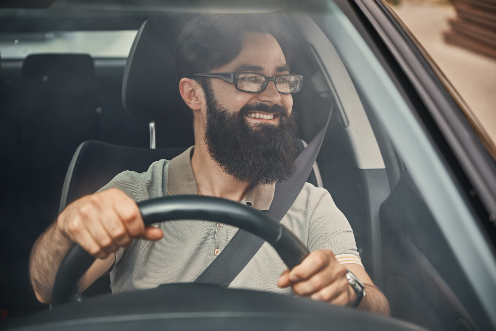 Homem feliz dirigindo um carro